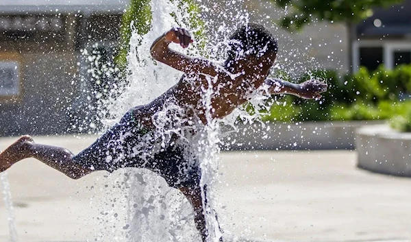 A boy plays in the splash pad at Howard Park, June 14,2022, in Indiana. (AP)