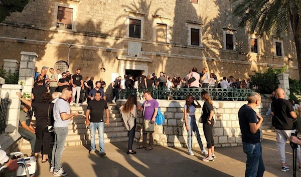 Palestinian Christians stand in front of the Mar Elias Church and Monastery following confrontations in the face of the provocative and barbaric storming conducting by Israeli settlers on July 23, 2023. (Social Media)