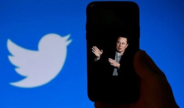 A phone screen displays a photo of Elon Musk with the Twitter logo shown in the background, in Washington, DC, October 4, 2022. (AFP)