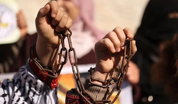 Palestinian women attend a protest in solidarity with female Palestinian prisoners held in Israeli jails, on December 2, 2021 (AFP)