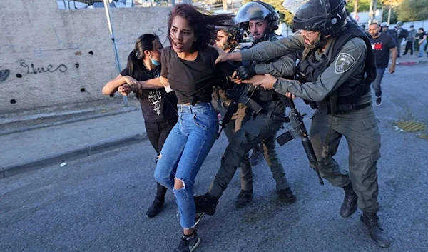 Israeli security forces try to detain a Palestinian woman in the east Jerusalem neighbourhood of Sheikh Jarrah on May 15, 2021 (Emmanuel Dunand/AFP)