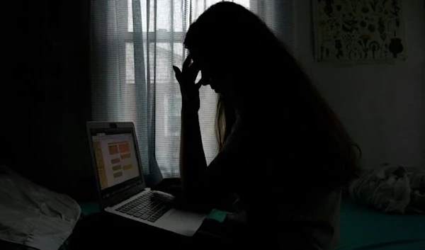 A woman in distress in front of her computer -undated- (AFP)