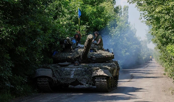 Ukrainian servicemen ride atop on a tank T-64 at the front line near Bakhmut, Donetsk region, Monday, July 3, 2023 (AP Photo/Alex Babenko, File)