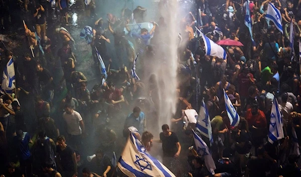 Riot police tries to clear demonstrators with a water canon during a protest against plans by Netanyahu's government to overhaul the judicial system, in Tel Aviv, Monday, July 24, 2023 (AP Photo)