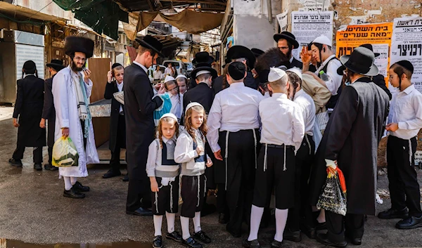 Ultra-Orthodox settlers stand along a street corner in in occupied Al-Quds -undated- September 27, 2020 (AFP)