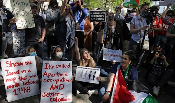 Activists protest the Israeli occupation's aggression on Gaza outside the Israeli Embassy in Washington, DC on May 18, 2021 (AFP)