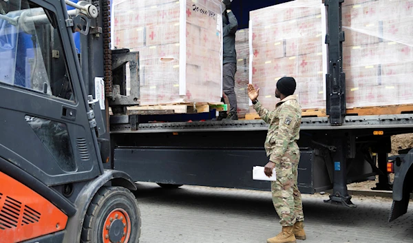 Paratroopers assigned to the 82nd Airborne Division unload humanitarian goods in support of the USAID in preparation for potential evacuees from Ukraine in Jasionka, Poland, on February 25, 2022 (AP)