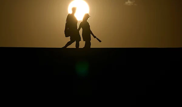 A couple walks in the scorching heat. (John Locher/AP)