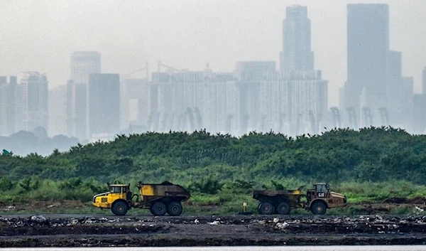 Trucks transport ash from incinerated garbage on Pulau Semakau island, which serves as Singapore's offshore landfill. (AFP)