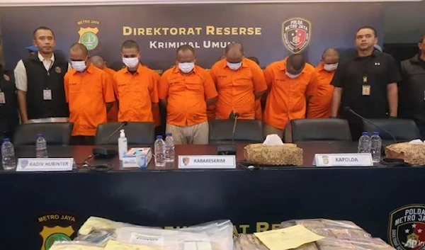 Indonesian police officers escort suspects and display the items of evidence during a press conference at Jakarta police headquarters in Jakarta, Indonesia, on Jul 20, 2023. (AP)