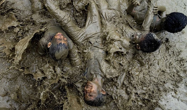 Children play in the mud in a paddy field during Asar Pandra, or paddy planting day at Bahunbesi, Nuwakot District, 30 miles North from Kathmandu, Nepal, Friday, June 30, 2023. (AP)