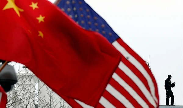 on Jan. 17, 2011, a Secret Service agent guards his post on the roof of the White House as a lamp post is adorned with Chinese and U.S. national flags in Washington, DC, US (AFP)