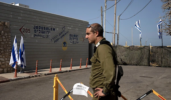 An Israeli Occupation Forces officer stands near a marker at a tourist area overlooking the Mediterranean Sea at the Israeli border with Lebanon in Rosh Hanikra, Israel, Thursday, Oct. 27, 2022. (AP)