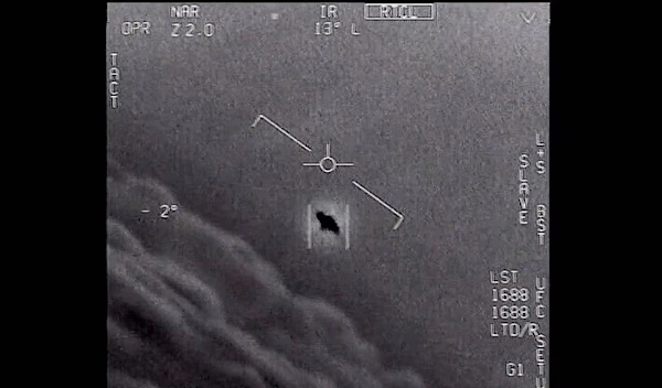 An unexplained object is seen at center as it soars high among the clouds in 2015, traveling against the wind, in this image from video provided by the Department of Defense. (DoD/AP)