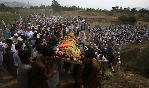 Relatives and mourners carry the casket of a victim who was killed in Sunday's suicide bomber attack in the Bajur district of Khyber Pakhtunkhwa, Pakistan, Monday, July 31, 2023 (AP)