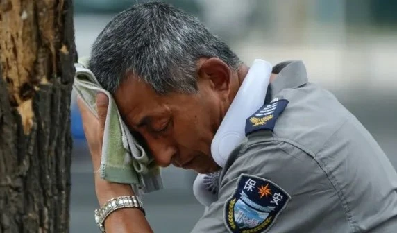 A security guard wipes sweat from his forehead in Beijing, China, on 3 July 2023. Photograph: Andy Wong/AP