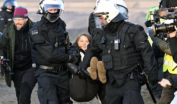 Police officers carry Swedish Greta Thunberg, the climate activist, during a protest action after the clearance of Luetzerath, Germany, on January 17, 2023. (AP)