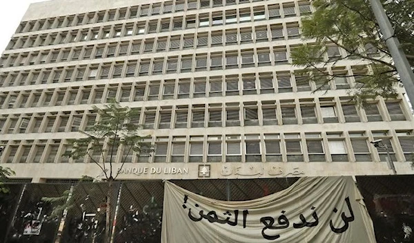 A banner saying "we will not pay the price" onNovember 27, 2019 hangs in front of the Lebanese Central Bank in Hamra, Beirut