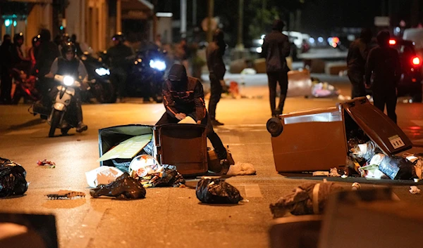 Protesters block a street with garbage cans in Colombes, outside Paris, France, Saturday, July 1, 2023. (AP)