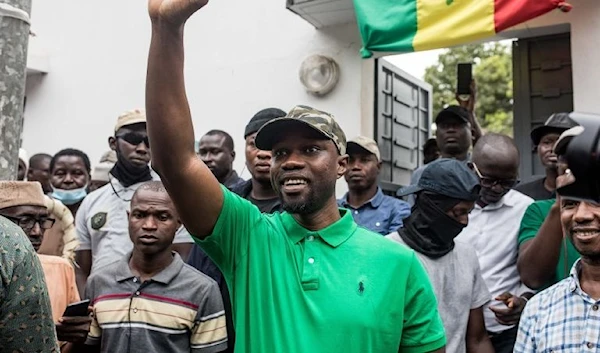 Opposition leader Ousmane Sonko waves to his supporters during a meeting in Ziguinchor, Senegal (AFP]