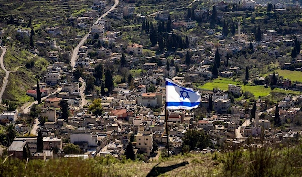 The Palestinian village of Burqa is seen as an Israeli flag is placed in the Jewish West Bank outpost of Homesh, January 17, 2022. (AP)