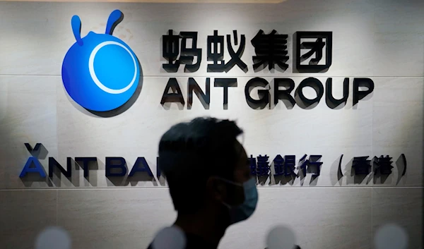 In this Friday, Oct. 23, 2020, photo, an employee walks past a logo of the Ant Group at their office in Hong Kong. (AP)