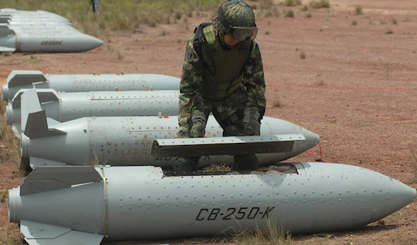 A Colombian Army bomb disposal expert opens the container of a Chilean-made CB-250K cluster bomb to extract the bomblets for destruction May 7, 2009, at the Marandua military base, Vichada department, Colombia (AFP)