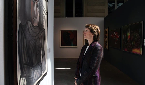 Marina Picasso, granddaughter of famous painter Pablo Picasso, poses in front of the 1943 work "Femme assise en robe grise" in Paris, in June 2013 (AFP)