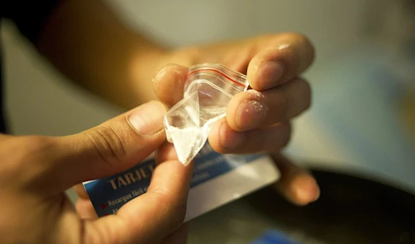 A Colombian drug dealer prepares cocaine for street sale in Bogota. (AFP)