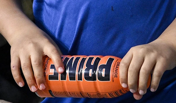 A child holds a PRIME hydration at to a baseball game in Los Angeles on March 31. ( AP )