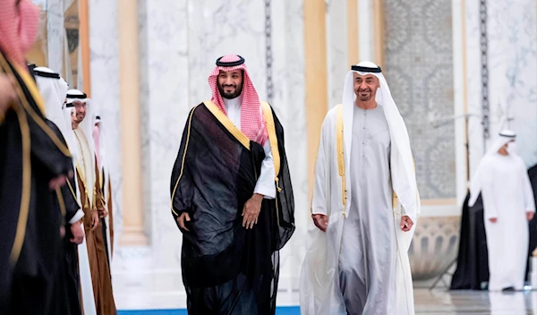 Saudi Crown Prince Mohammed bin Salman, left, and Abu Dhabi's powerful crown prince, Sheikh Mohammed bin Zayed Al Nahyan, walk into a reception in Abu Dhabi, United Arab Emirates, Tuesday, Dec. 7, 2021 (Emirati Ministry of Presidential Affairs via AP)