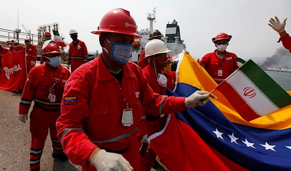 A Venezuelan oil worker holding a small Iranian flag attends a ceremony for the arrival of Iranian oil tanker Fortune at the El Palito refinery near Puerto Cabello, Venezuela on May 25, 2020. (AP)