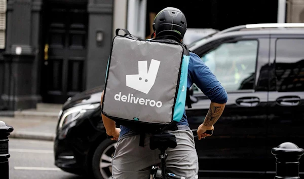 A Deliveroo food courier makes a delivery in central London on September 11, 2019 (AFP)