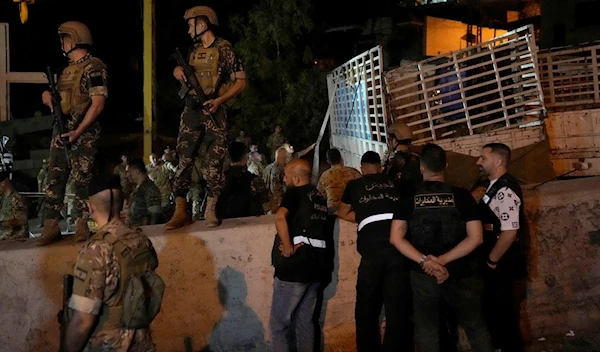 Lebanese soldiers stand guard next to an overturned truck, right, in the Christian town of Kahaleh, Lebanon, Wednesday, Aug. 9, 2023. (AP)