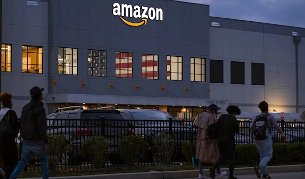 People arrive for work at the Amazon distribution center in New York, on October 25, 2021. (AP)