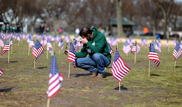 A war veteran cries while helping in the set up of American flags on the National Mall in Washington, D.C., in March 2014. (AFP)