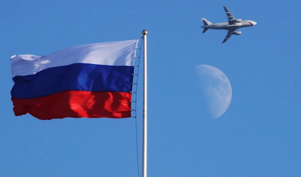 A plane flies over the Russian flag atop the Konstantin Palace in St.Petersburg, Russia, Friday, July 24, 2015. (AP)