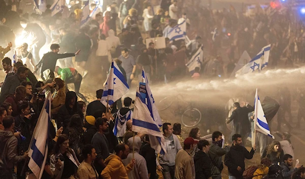 Israeli police use a water cannon to disperse demonstrators blocking a highway during a protest against plans by Prime Minister Benjamin Netanyahu's government to overhaul the judicial system in Tel Aviv, Israel, Monday, March 27, 2023. (AP)