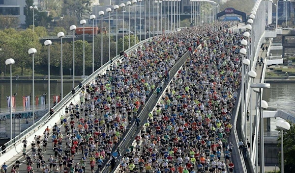 Participants in the 40th Vienna City Marathon cross the Reichs bridge at the start of the race in Vienna, Austria on April 24, 2023. (AFP)