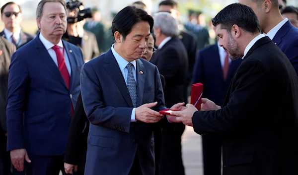 Taiwan's Vice President William Lai Ching-te, center, receives the key of the city from Mayor Oscar Rodriguez after landing at Silvio Pettirossi airport in Luque, Paraguay, August 14, 2023 (AP)