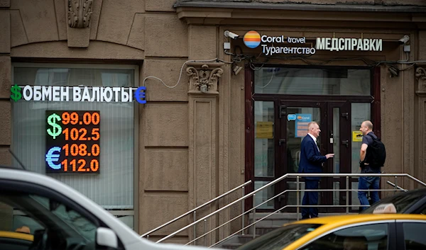 Two men talk to each other at the entrance of a currency exchange office in Moscow, Russia, Monday, August 14, 2023 (AP)