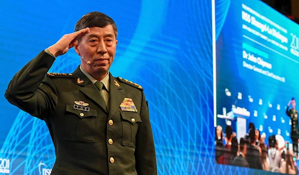 Chinese Defense Minister Li Shangfu salutes the audience before delivering a speech during the 20th Shangri-La Dialogue Asia security summit in Singapore in June 2023. (AFP-JIJI)