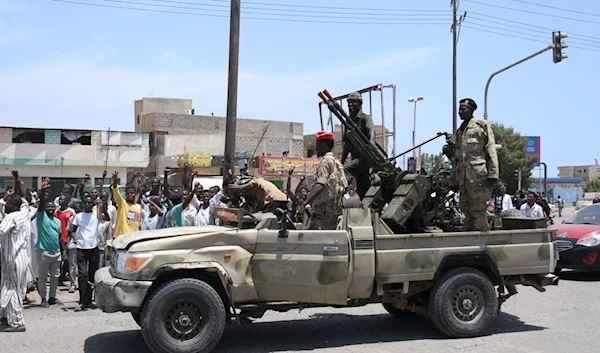 Sudanese greet army soldiers, loyal to army chief Abdel Fattah al-Burhan, in the Red Sea city of Port Sudan on April 16, 2023 (AFP)