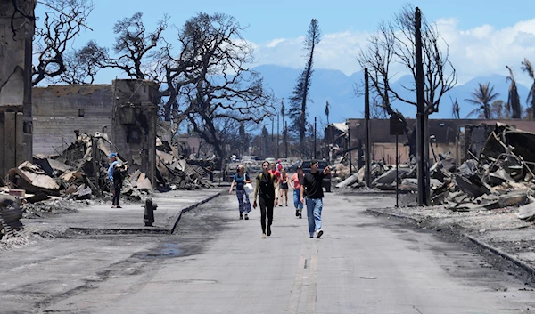 People walk along Main Street past wildfire damage, in Lahaina, Hawaii on Friday, Aug. 11, 2023 (AP)