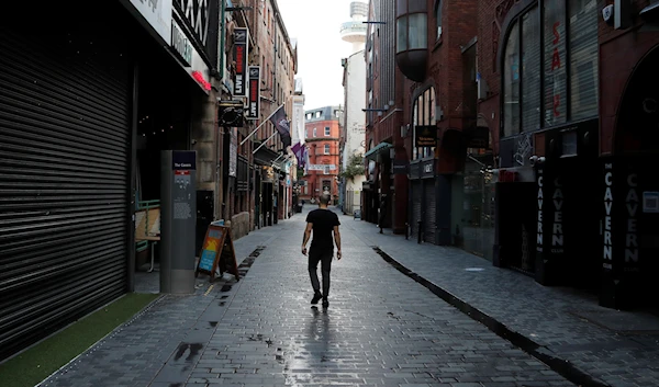 a lone man walks, past the famous Cavern club and other closed pubs and bars Liverpool, England Oct. 14, 2020 (AP)