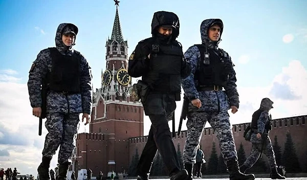 Russian Police and National Guard (Rosgvardia) servicemen patrol Red Square in front of the Spasskaya tower of the Kremlin in Moscow on October 24, 2022. (AFP)