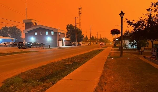 The town of Fort Smith, Canada, sits under the glow of the wildfires in the Northwest Territories on August 13, 2023. (Handout/AFP)