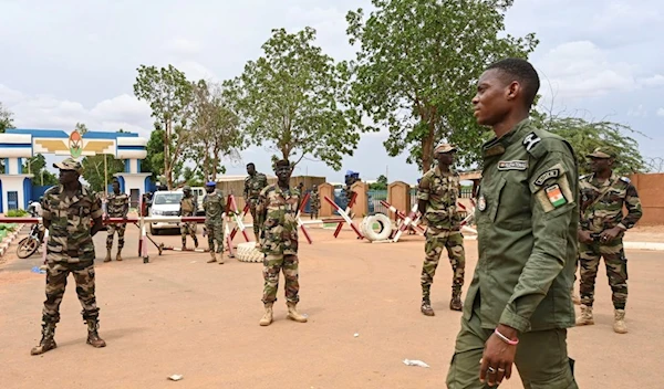 Nigerien soldiers stand guard as supporters of Niger's National Council for the Safeguard of the Homeland (CNSP) gather for a demonstration in Niamey on August 11, 2023 near a French airbase in Niger (AFP)