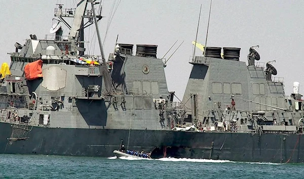 In this Oct. 15, 2000, file photo, investigators in a speed boat examine the hull of the USS Cole at the Yemeni port of Aden, after an explosion ripped a hole in the Navy destroyer. (AP)