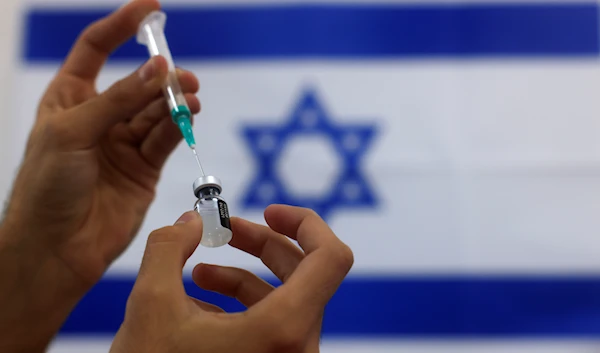 An Israeli military paramedic prepares a syringe January 7 2021 (AP)